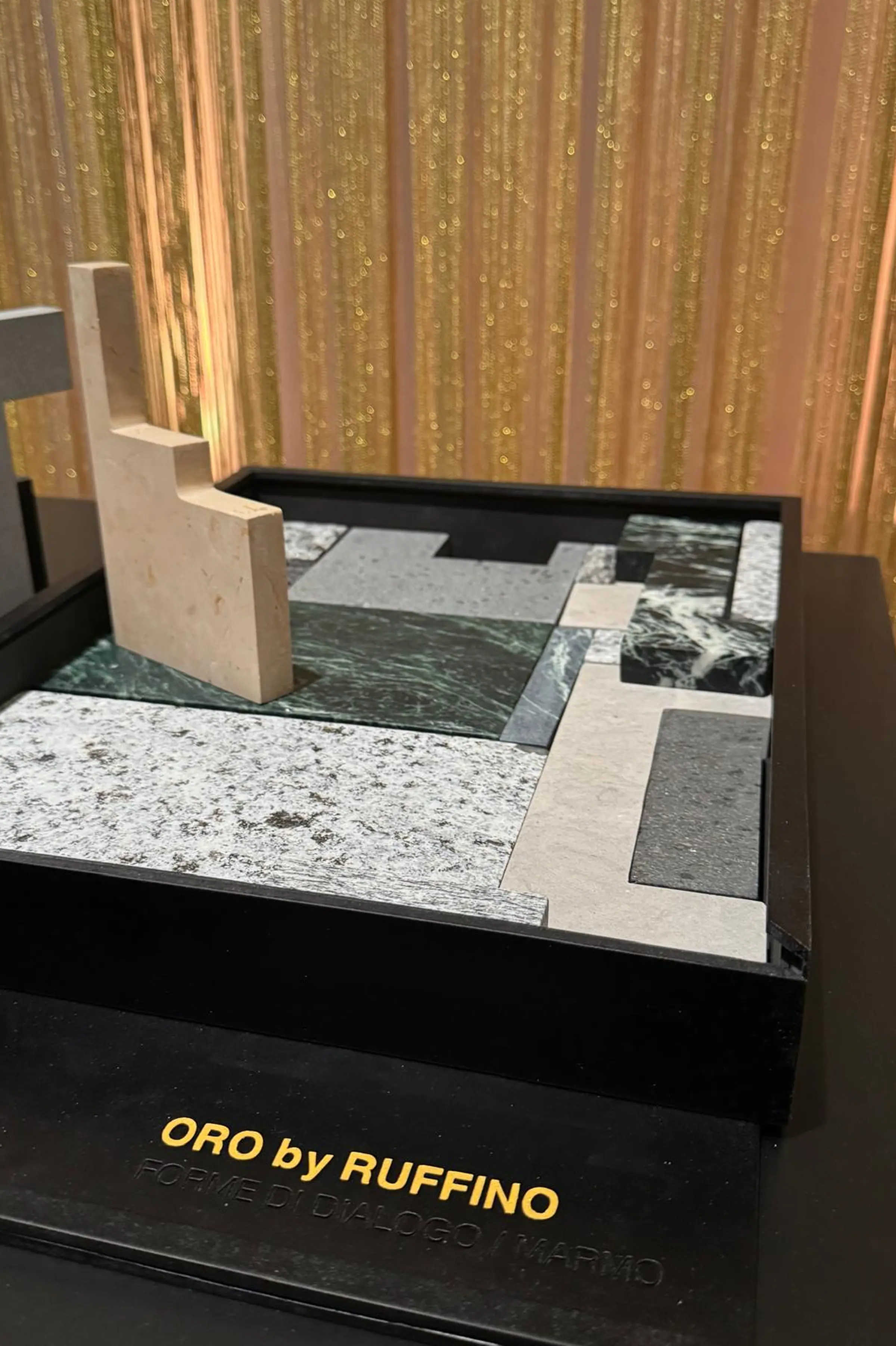 Vista d'insieme dell'installazione Forme di Dialogo alla Triennale di Milano - puzzle di sagome in marmo, legno e carta con box ORO by RUFFINO, progetto Uros Mihic x Trapattoni Marmi 2025