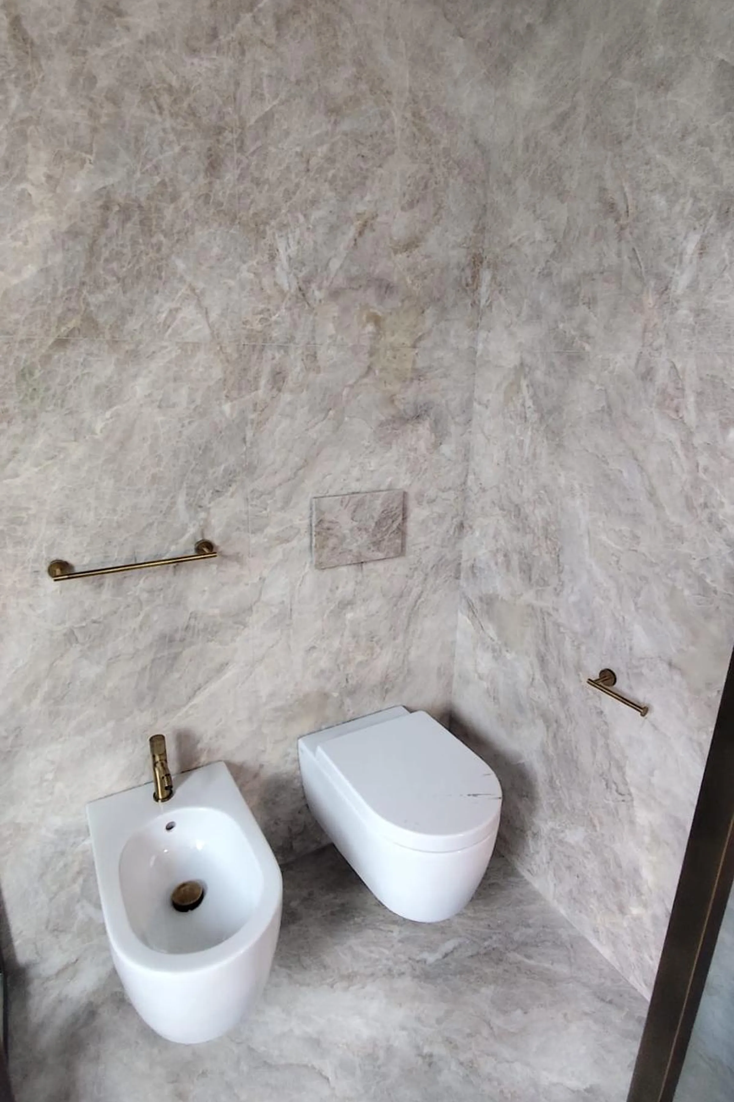 Rivestimento a parete, pavimento, sanitari sospesi e rubinetteria in ottone del secondo bagno padronale in Taj Mahal lucido - progetto LC Atelier x Trapattoni Marmi, centro storico di Milano
