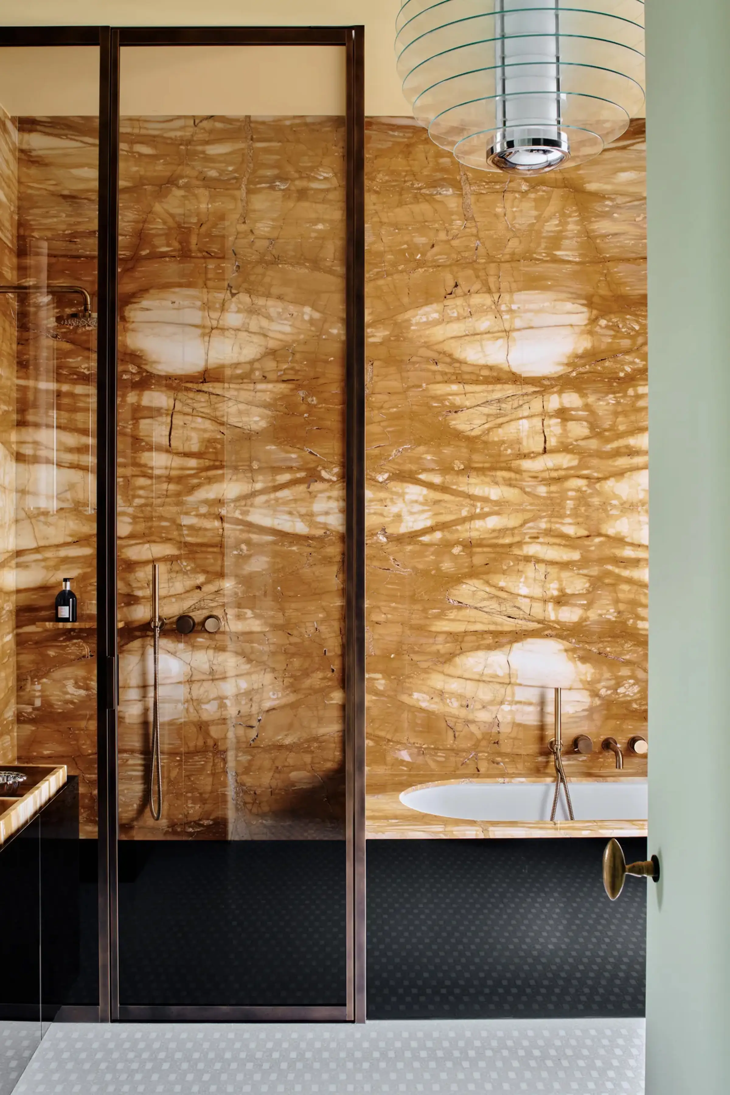 Rivestimento a parete in Giallo Siena lucido a macchia aperta con piano lavabo e box doccia in dimora privata di lusso nel centro storico di Milano – LC Atelier x Trapattoni Marmi