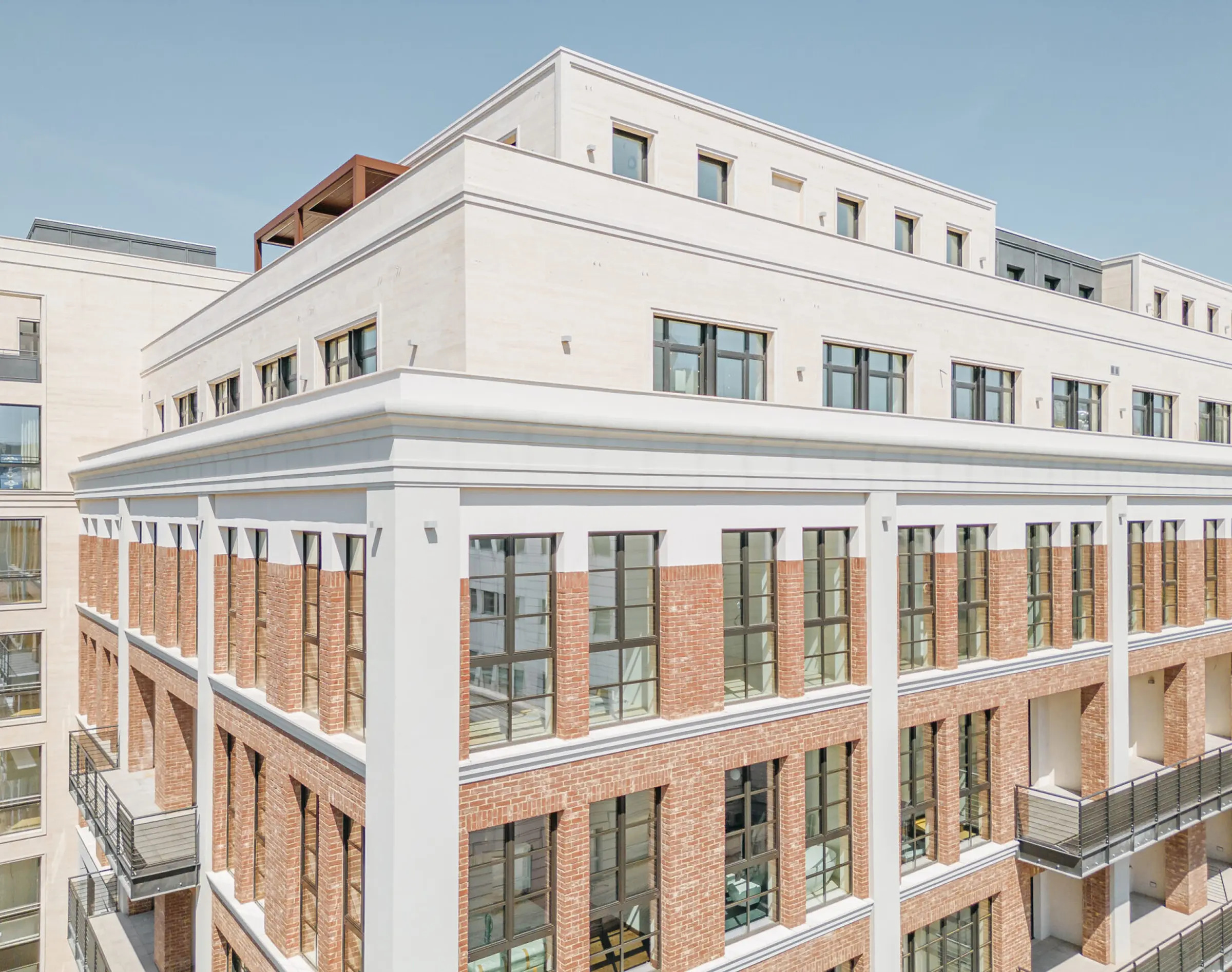 Dettaglio dei volumi della penthouse del Washington Building a Milano rivestiti in Travertino Romano con giunti orizzontali, infissi neri a filo muro e pergola in corten - lavorazione artigianale e posa in opera Trapattoni Marmi