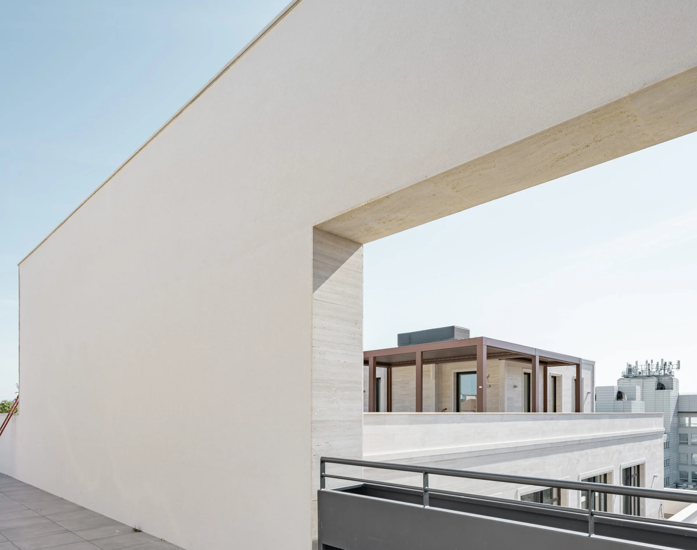 Prospetto del Washington Building su Via Irnerio a Milano: torre con decorazioni incise e archi a tutto sesto in Travertino Romano, paramento in mattone rosso e corpo residenziale Borletti - fornitura e posa in opera Trapattoni Marmi