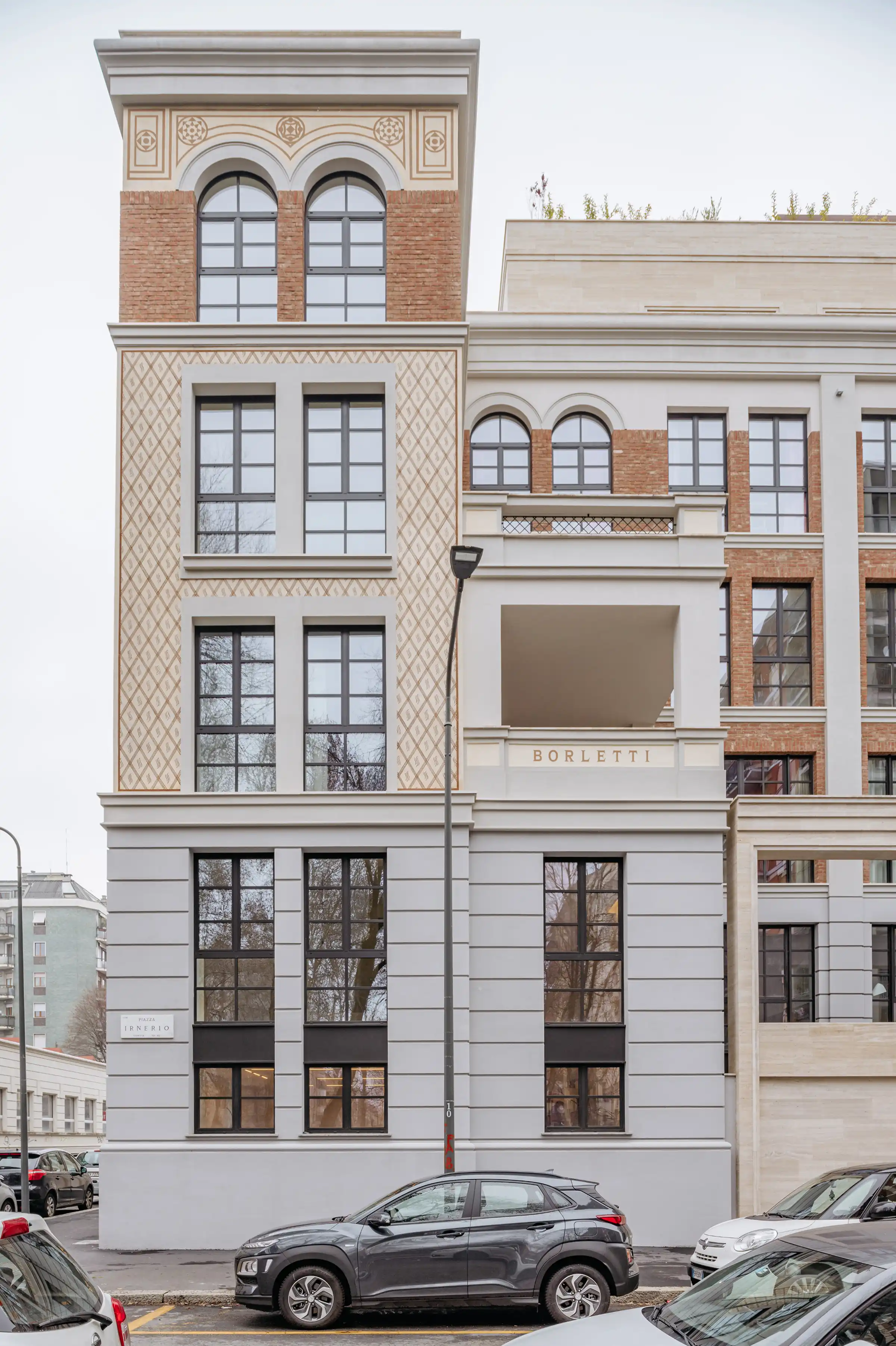 Prospetto simmetrico del Washington Building a Milano con rivestimento in Travertino Romano a venatura orizzontale, balconi con fioriere in metallo scuro e cornicioni in pietra - fornitura e posa in opera Trapattoni Marmi, quartiere Washington