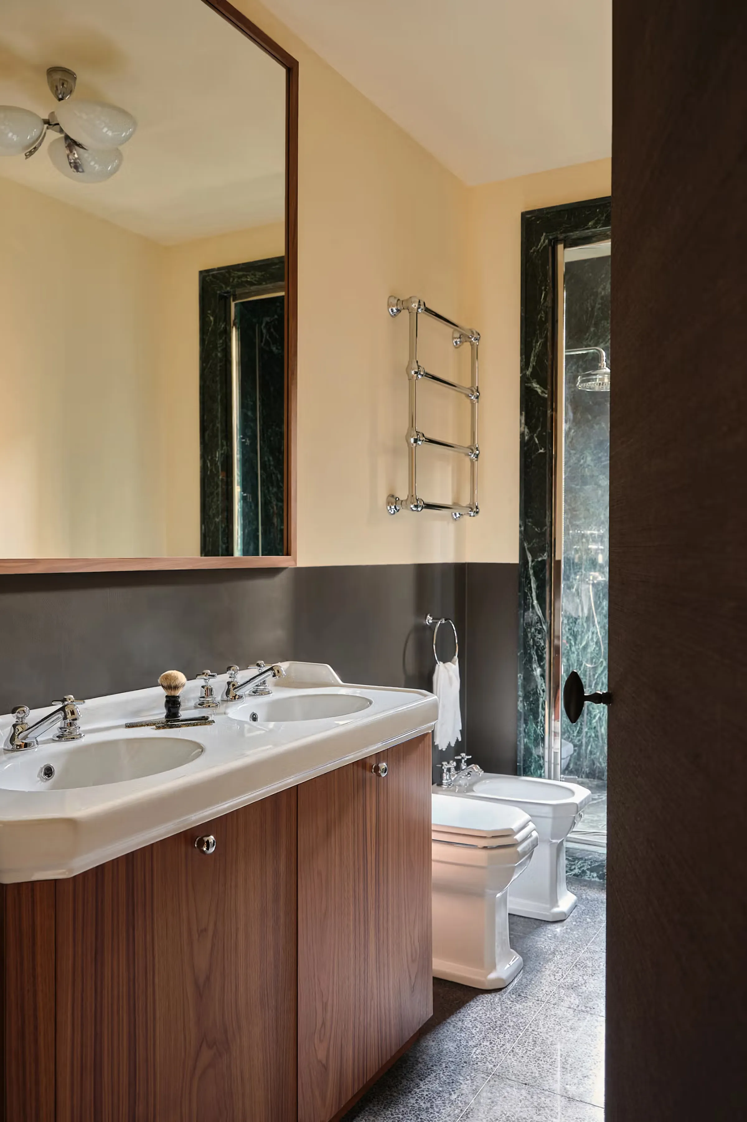 Bagno della dimora ai Navigli: doppio lavabo con piano integrato, mobile in noce, cornici specchio e porta doccia in Verde Alpi lucido, sanitari d'epoca e scaldasalviette cromato - dimora privata ai Navigli, progetto LC Atelier x Trapattoni Marmi