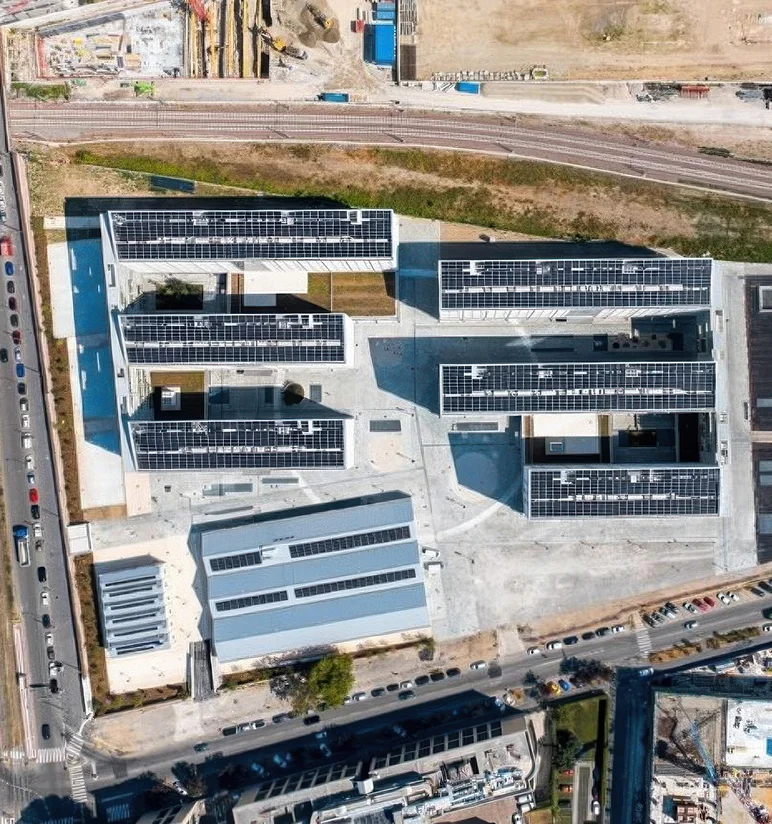 Vista aerea ravvicinata del Villaggio Olimpico Milano-Cortina 2026 a Scalo Porta Romana con coperture fotovoltaiche e pavimentazione esterna in Pietra di Luserna a spacco naturale - Trapattoni Marmi