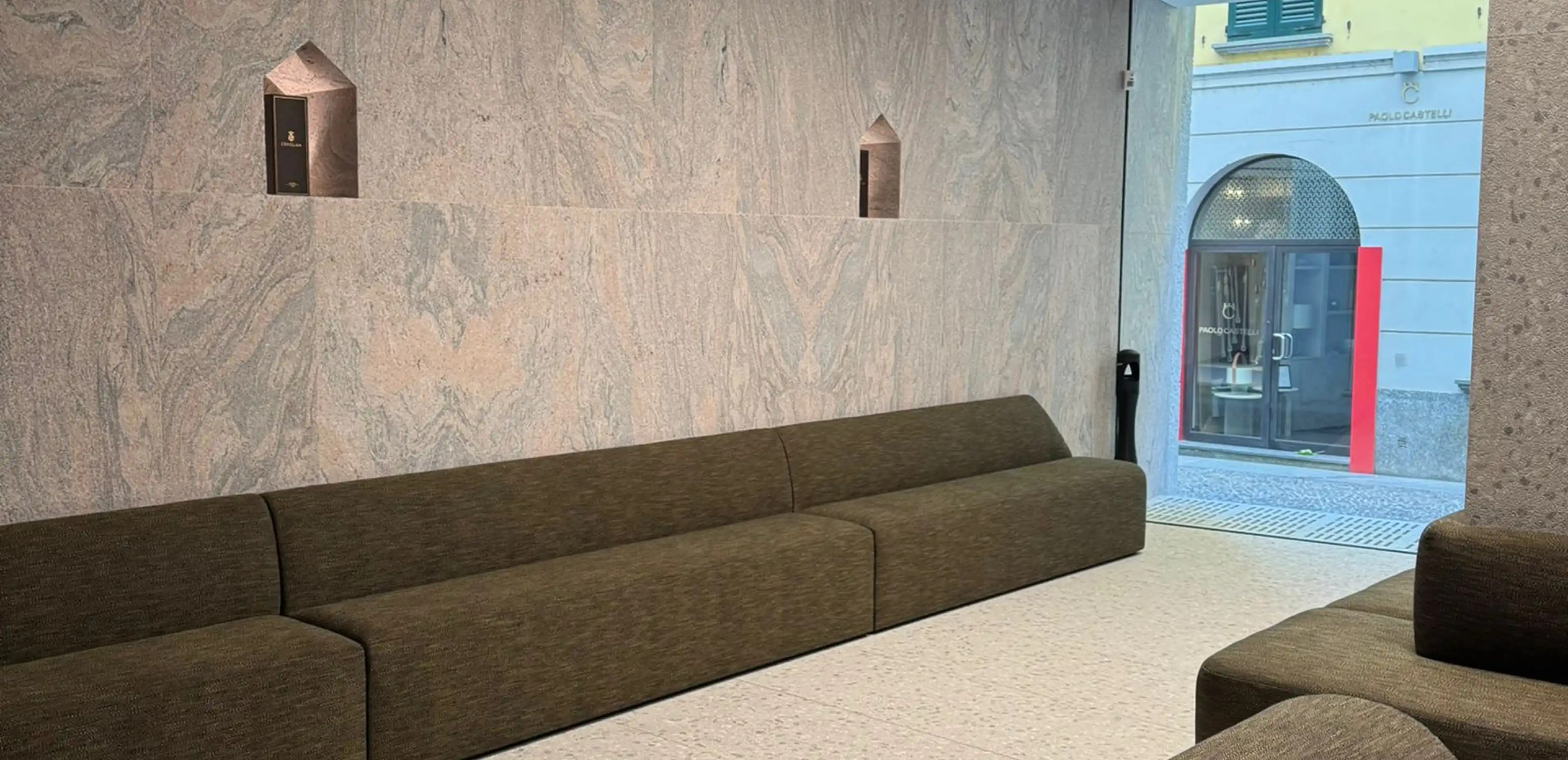 Lobby dello showroom in Via Fiori Chiari a Milano con rivestimento a parete in Granito Juparanà Rosa a macchia aperta e pavimento in Agglotech SB220 Giudecca sabbiato e spazzolato - fornitura e posa Trapattoni Marmi