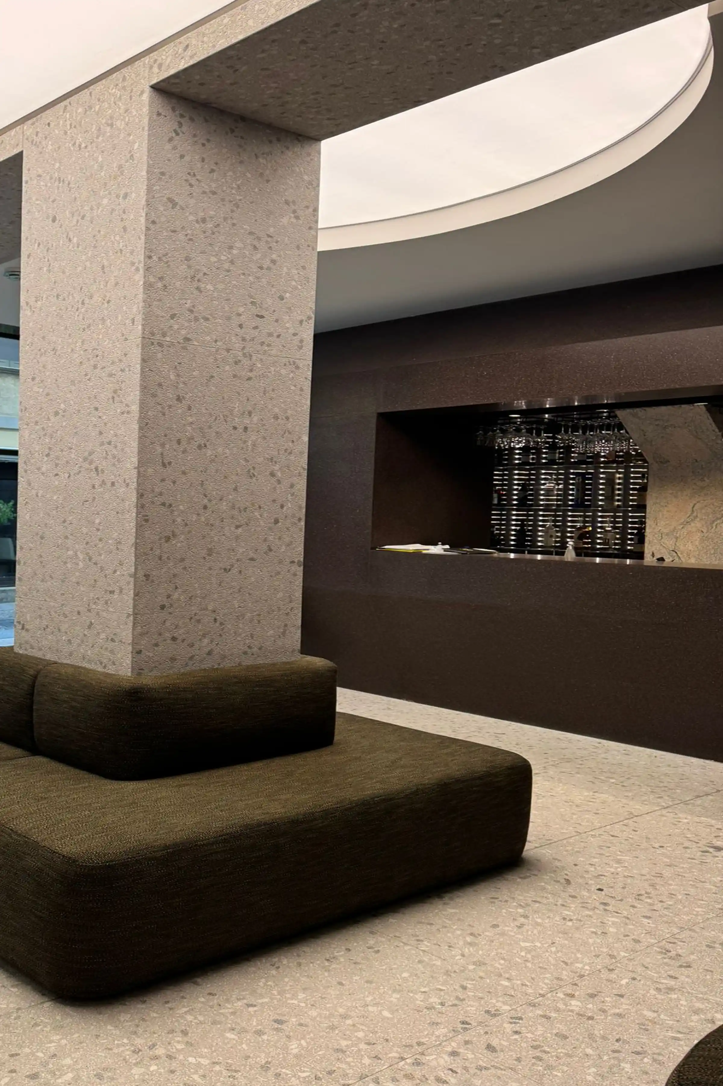 Vista della lobby dello showroom Brera con colonna in Granito Juparanà Rosa bancone in Agglotech Profido e pavimento in Agglotech SB220 Giudecca - fornitura e posa Trapattoni Marmi Milano