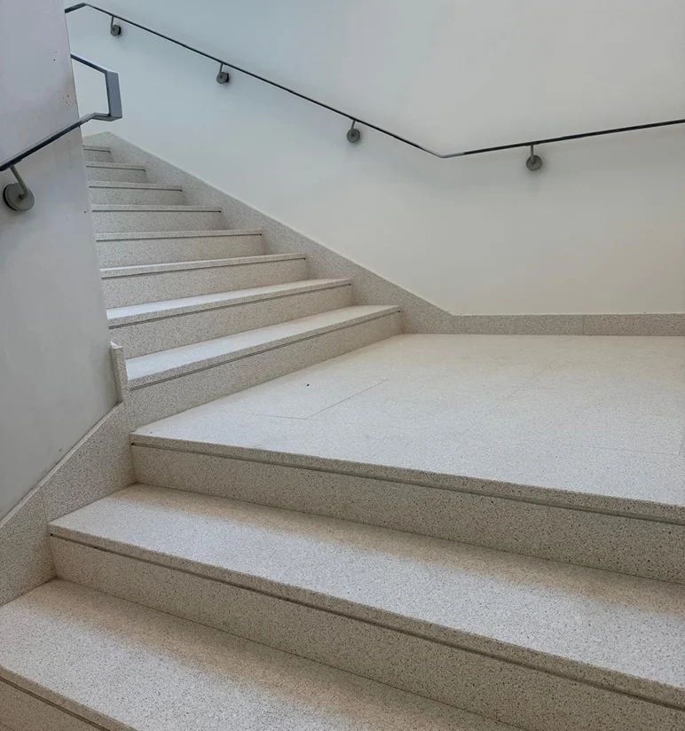 Scala padronale con gradini e pavimento in Agglotech SB134 Crema spazzolato negli spazi comuni della TheTris Tower a Famagosta Milano - fornitura e posa Trapattoni Marmi
