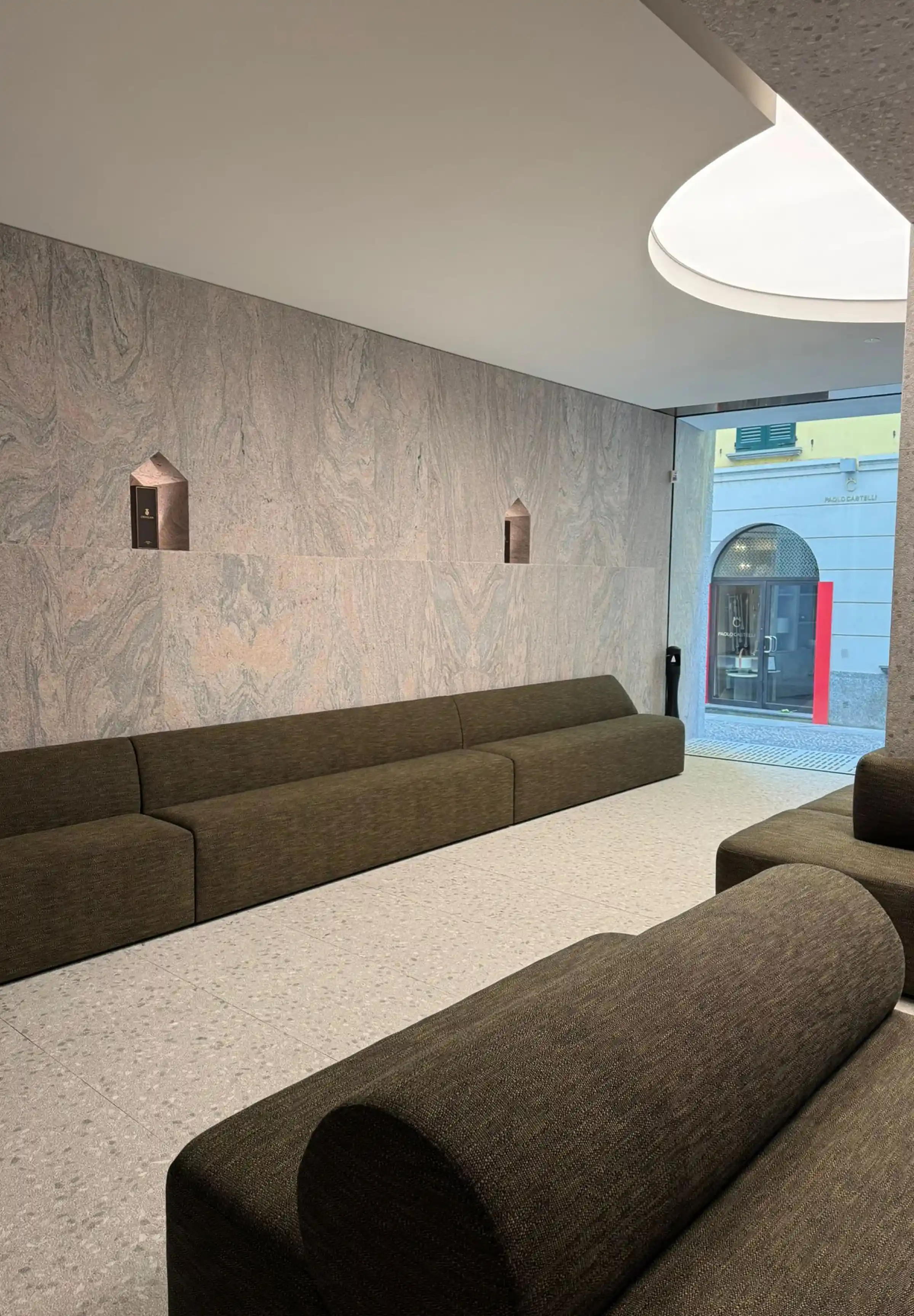 Showroom in Via Fiori Chiari a Brera, Milano: pavimento in Agglotech SB220 Giudecca sabbiato e spazzolato, rivestimento in Granito Juparana Rosa, colonna monolitica in Granito Himalaya e parete in Calcite Blue - Trapattoni Marmi